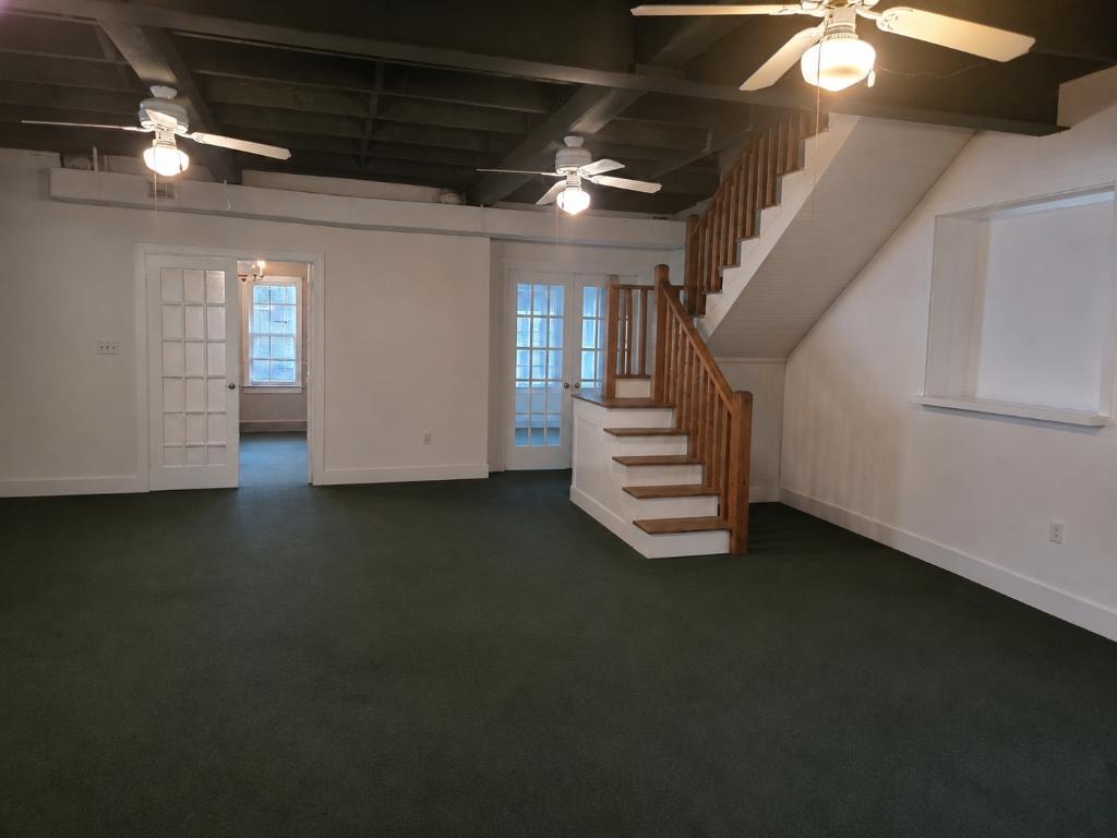 Open interior space with original staircase and exposed ceiling beams at 19 Talonah